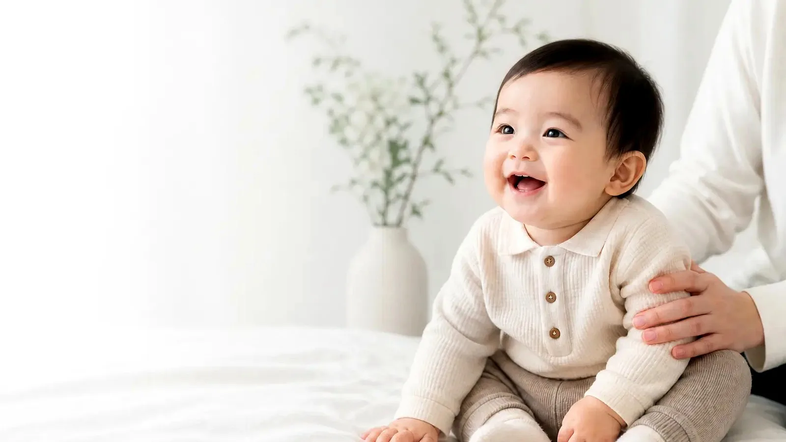窓辺の光の中で座っている赤ちゃん